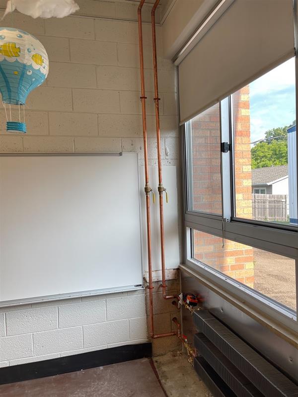Hydronic piping in classroom corner